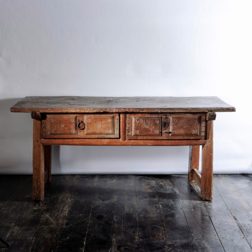 An 18th-century Spanish wooden console table featuring two carved drawer fronts with iron handles and a thick timber top. View IV