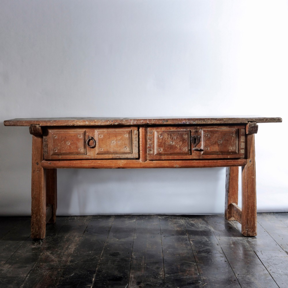 An 18th-century Spanish wooden console table featuring two carved drawer fronts with iron handles and a thick timber top. View V