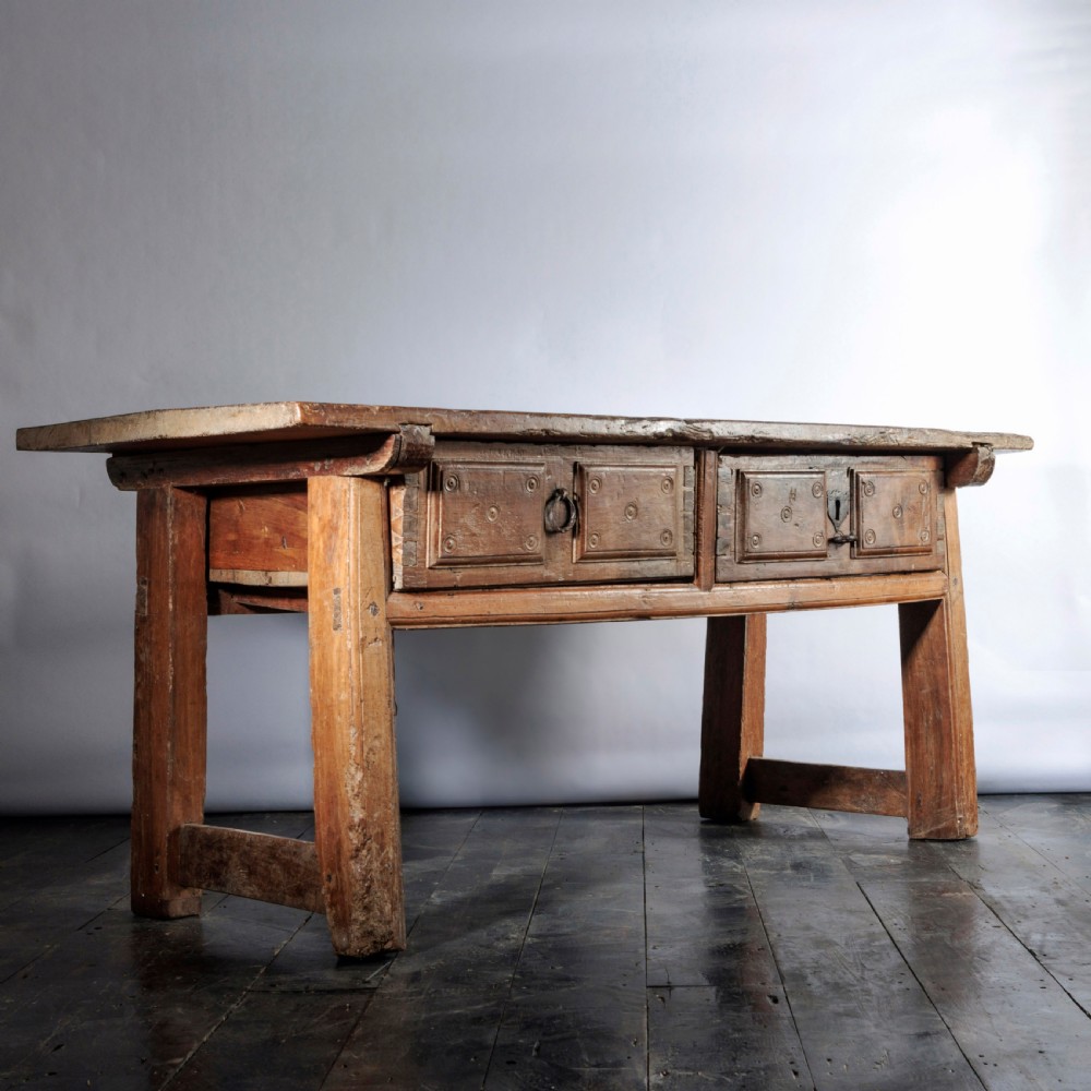 An 18th-century Spanish wooden console table featuring two carved drawer fronts with iron handles and a thick timber top. View XV