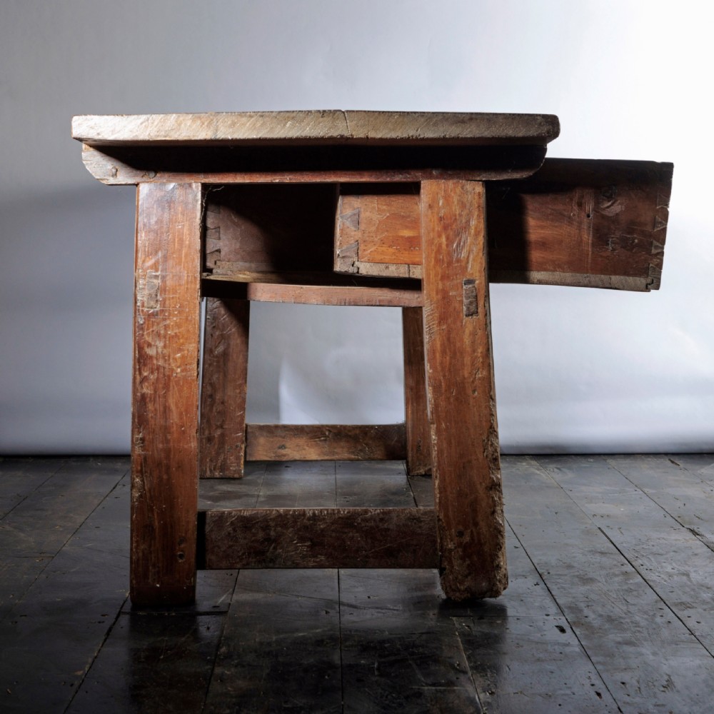 An 18th-century Spanish wooden console table featuring two carved drawer fronts with iron handles and a thick timber top. View XVI