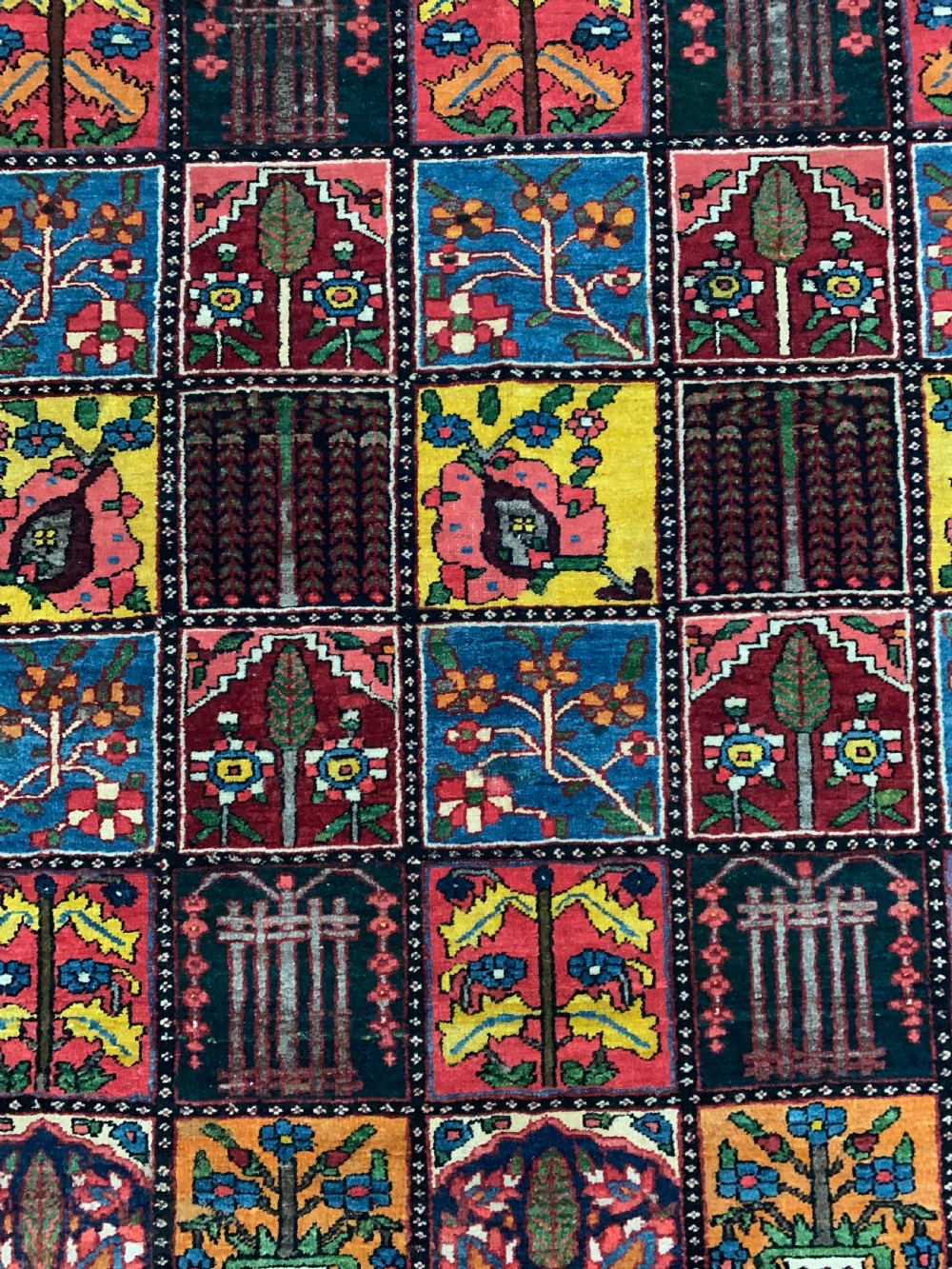 A hand-knotted Bakhtiari Persian wool rug featuring a rectangular garden compartment panel design in red, blue, green, and yellow. View II