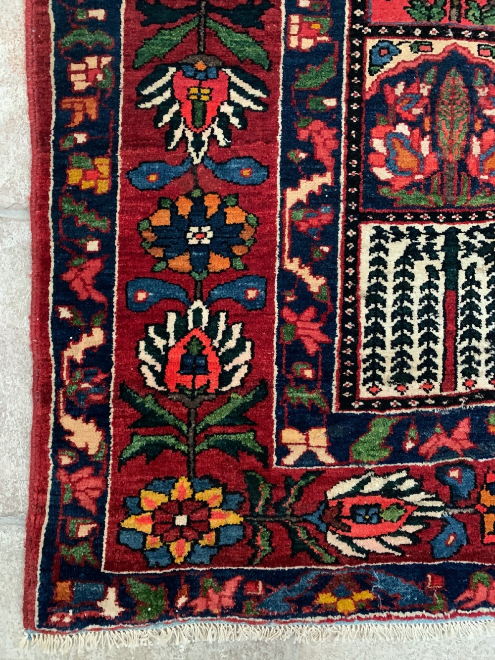 A hand-knotted Bakhtiari Persian wool rug featuring a rectangular garden compartment panel design in red, blue, green, and yellow. View III