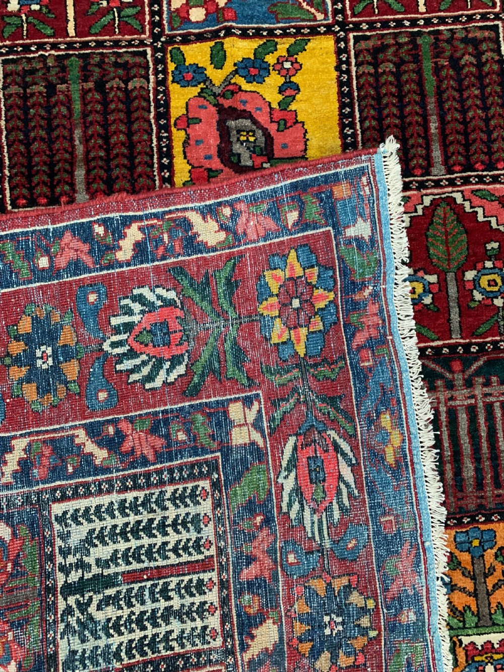 A hand-knotted Bakhtiari Persian wool rug featuring a rectangular garden compartment panel design in red, blue, green, and yellow. View IV