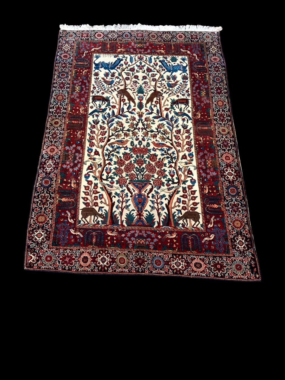 A hand-knotted Persian Sarouk wool rug featuring a central Tree of Life design populated with birds and animals on a cream field framed by a deep red floral border. View VIII