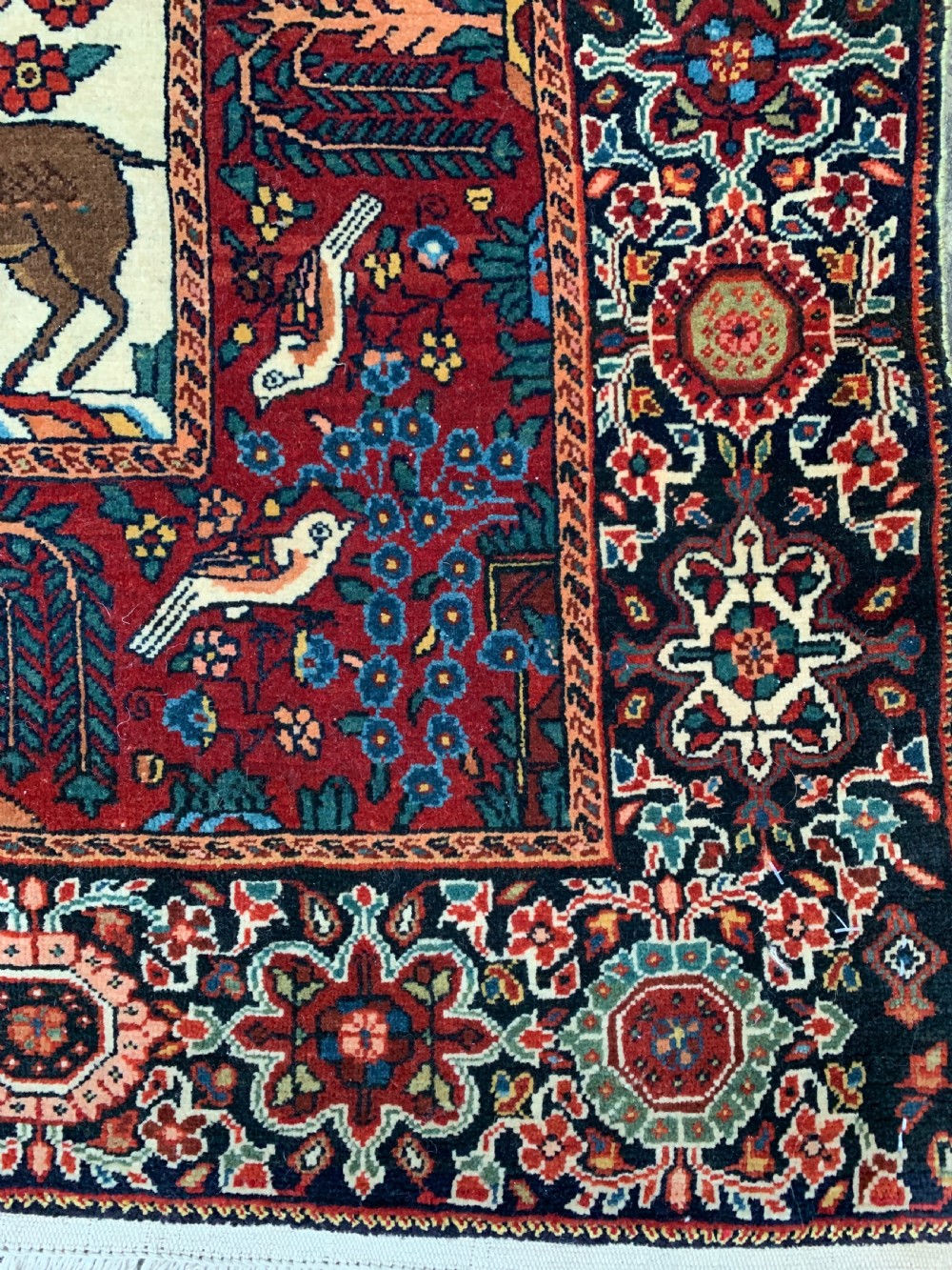 A hand-knotted Persian Sarouk wool rug featuring a central Tree of Life design populated with birds and animals on a cream field framed by a deep red floral border. View II