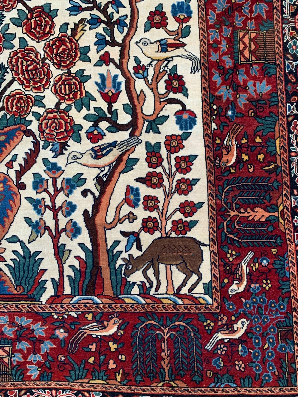 A hand-knotted Persian Sarouk wool rug featuring a central Tree of Life design populated with birds and animals on a cream field framed by a deep red floral border. View III