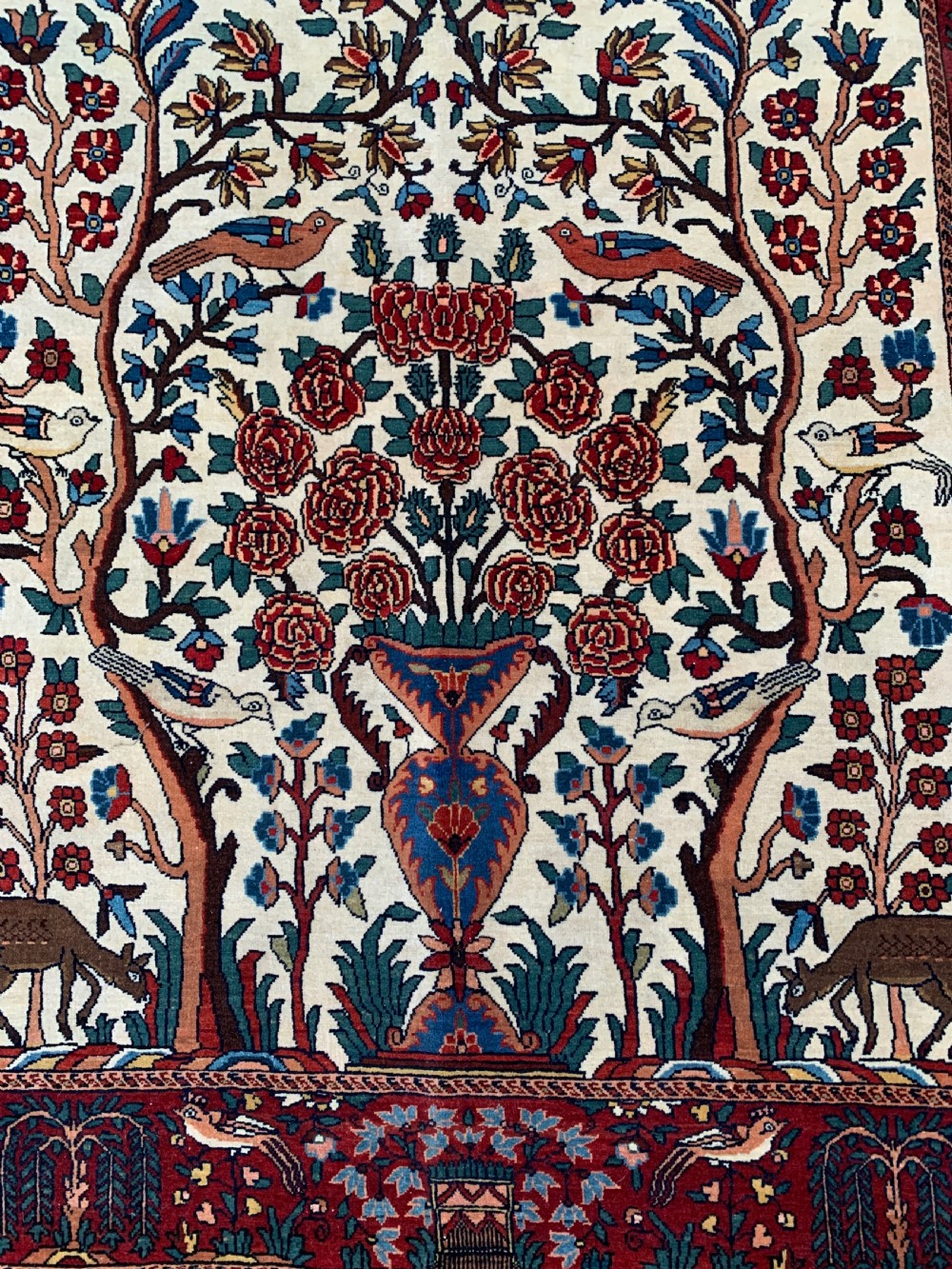 A hand-knotted Persian Sarouk wool rug featuring a central Tree of Life design populated with birds and animals on a cream field framed by a deep red floral border. View IV