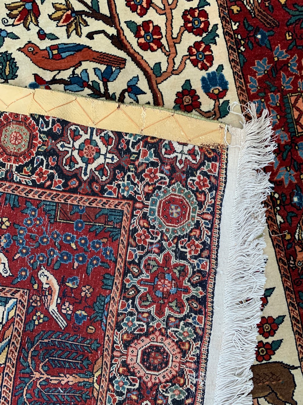 A hand-knotted Persian Sarouk wool rug featuring a central Tree of Life design populated with birds and animals on a cream field framed by a deep red floral border. View VII