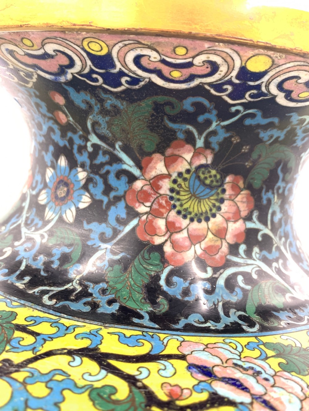 A bulbous 19th-century Chinese cloisonne enamel vase with a flared neck, featuring circular yellow dragon medallions surrounded by dense floral scrollwork on a dark blue ground. View V