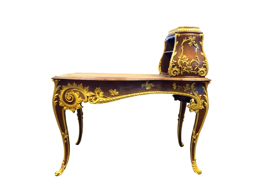 A 19th-century dark wood writing desk featuring elaborate gilt-bronze floral ormolu mounts, cabriole legs, and an asymmetrical raised side superstructure. View II
