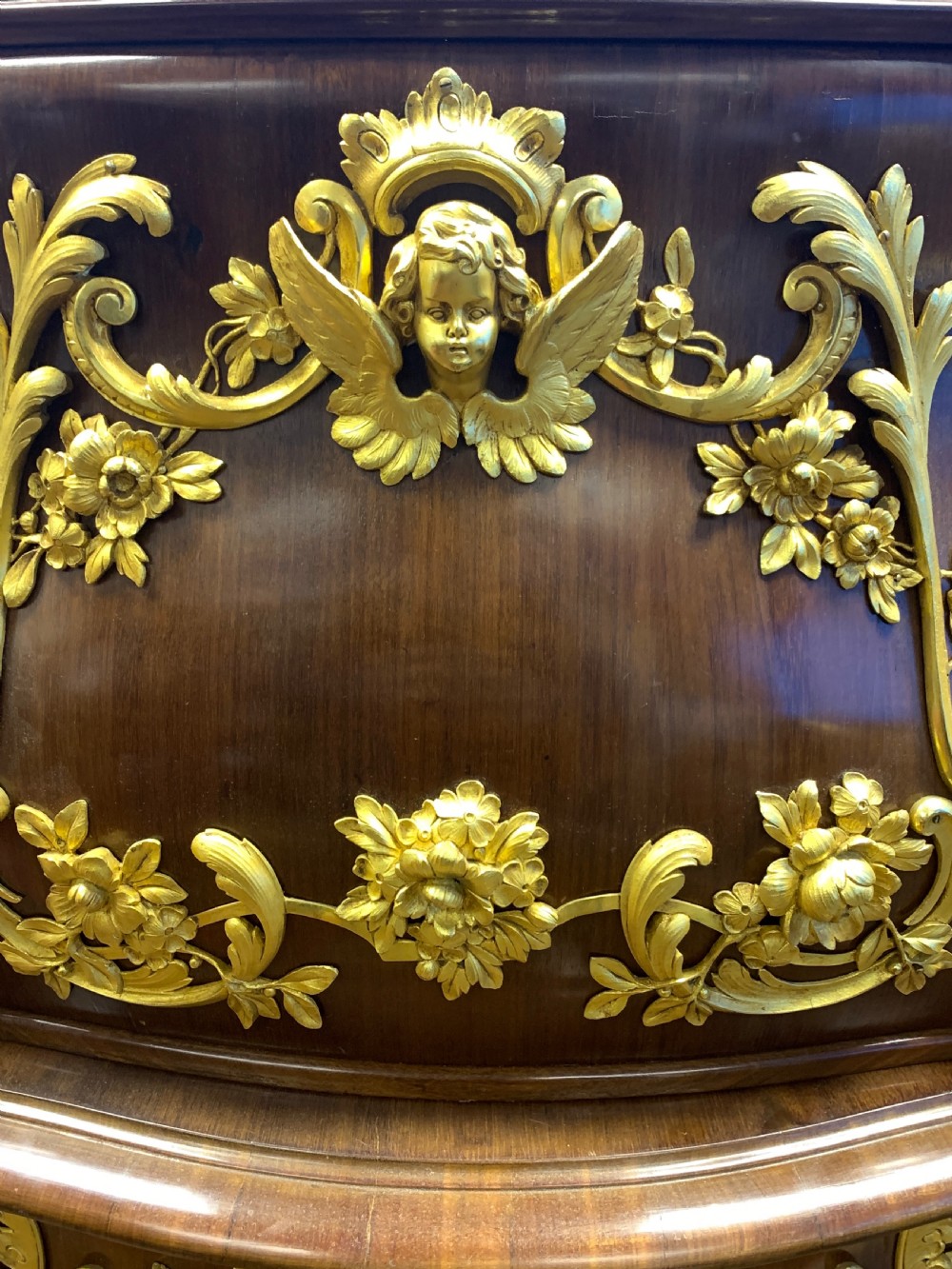 A 19th-century dark wood writing desk featuring elaborate gilt-bronze floral ormolu mounts, cabriole legs, and an asymmetrical raised side superstructure. View IV