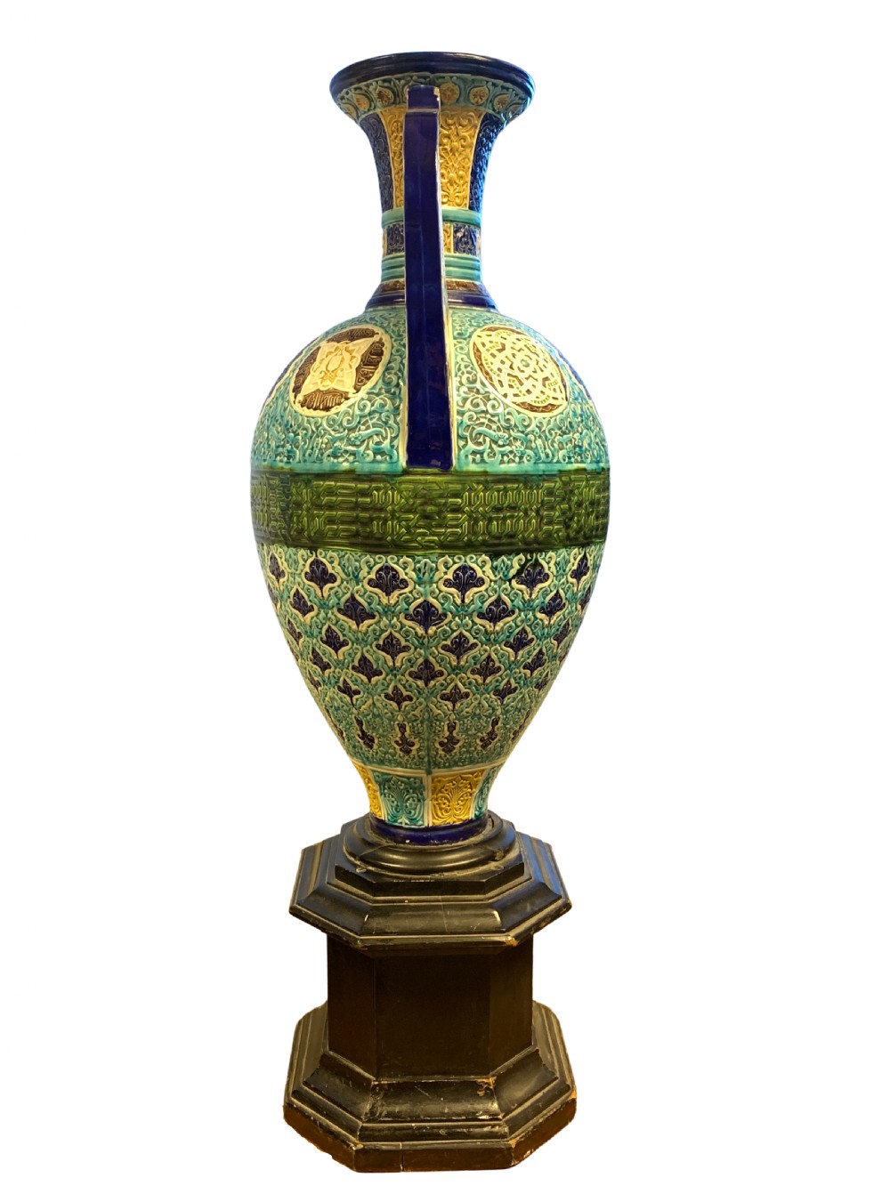 A tall 19th-century Alhambra-style ceramic vase featuring winged handles, arabesque relief decoration, and turquoise and cobalt glazes on an octagonal black base. View II