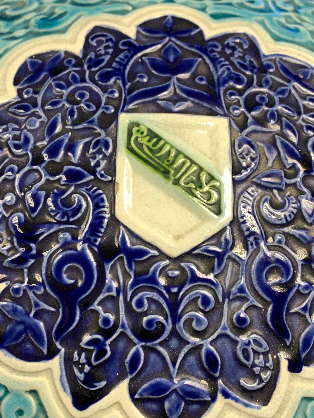 A tall 19th-century Alhambra-style ceramic vase featuring winged handles, arabesque relief decoration, and turquoise and cobalt glazes on an octagonal black base. View V