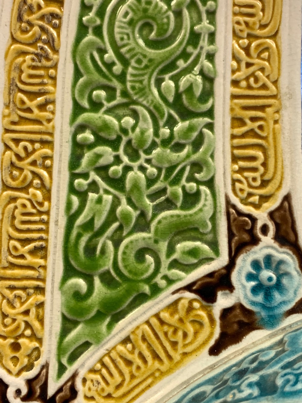 A tall 19th-century Alhambra-style ceramic vase featuring winged handles, arabesque relief decoration, and turquoise and cobalt glazes on an octagonal black base. View VII