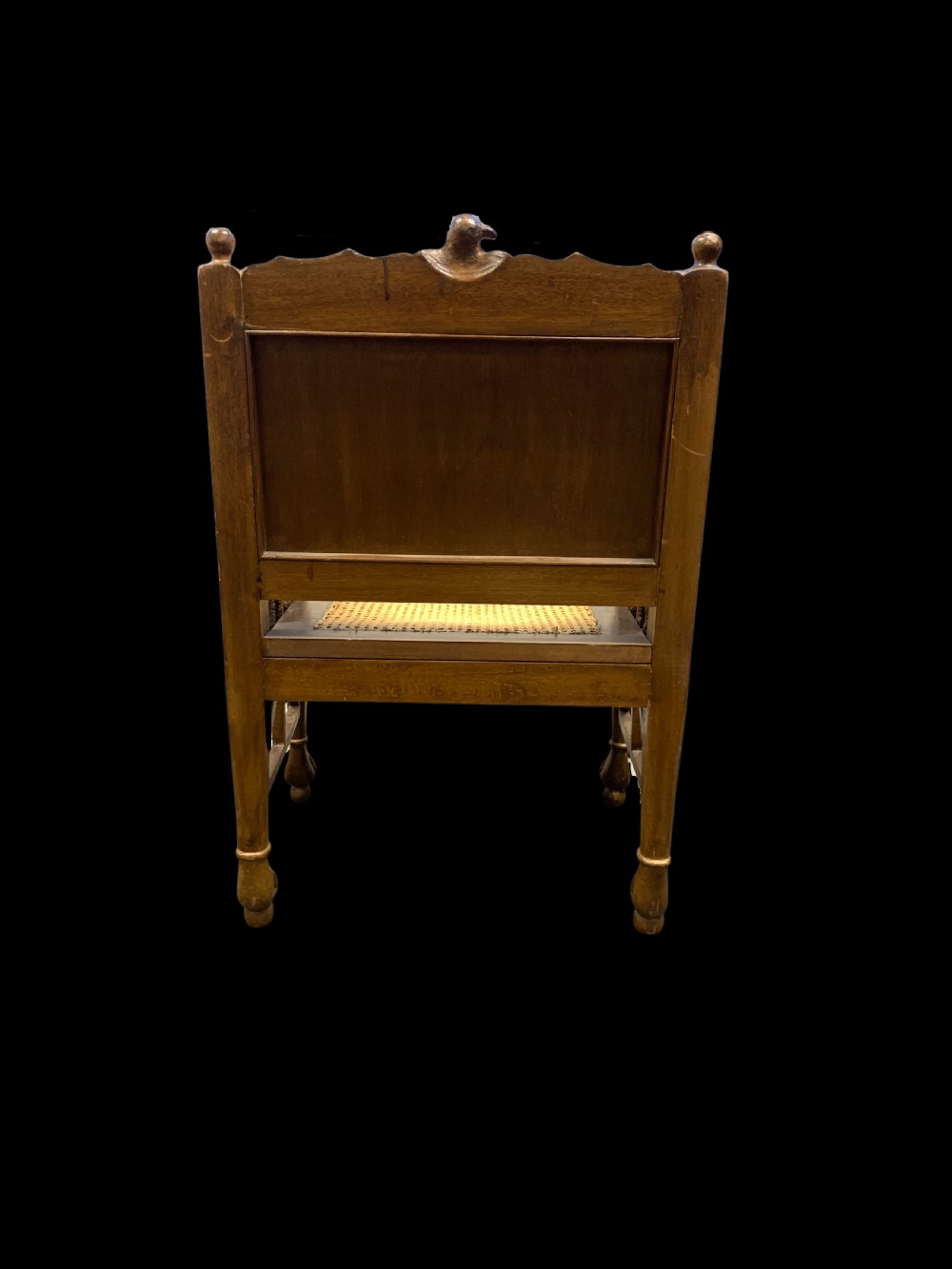 A three-piece nineteenth-century Egyptian Revival furniture suite consisting of a settee and two armchairs with carved winged crestings, figural marquetry backrests, and cane seats. View V