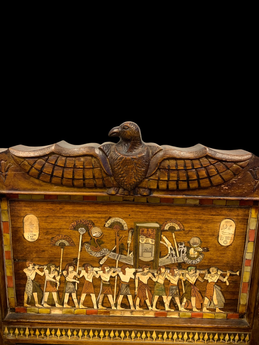 A three-piece nineteenth-century Egyptian Revival furniture suite consisting of a settee and two armchairs with carved winged crestings, figural marquetry backrests, and cane seats. View XI