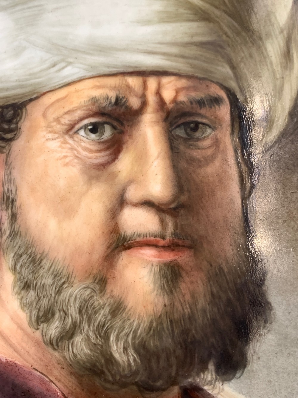 A 19th-century portrait painting depicting a bearded man in a white turban and maroon robe within a carved giltwood frame. View IV
