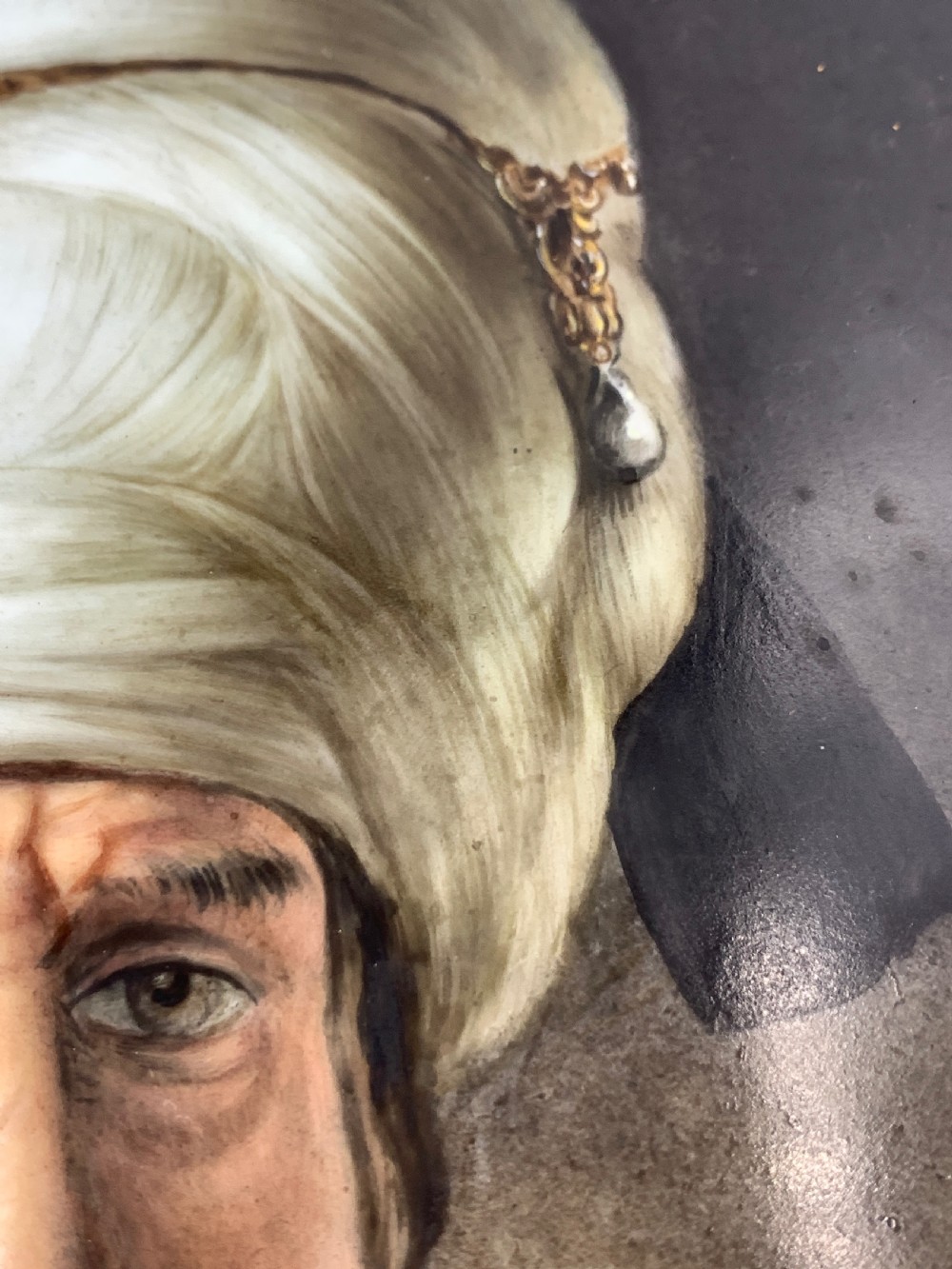 A 19th-century portrait painting depicting a bearded man in a white turban and maroon robe within a carved giltwood frame. View V