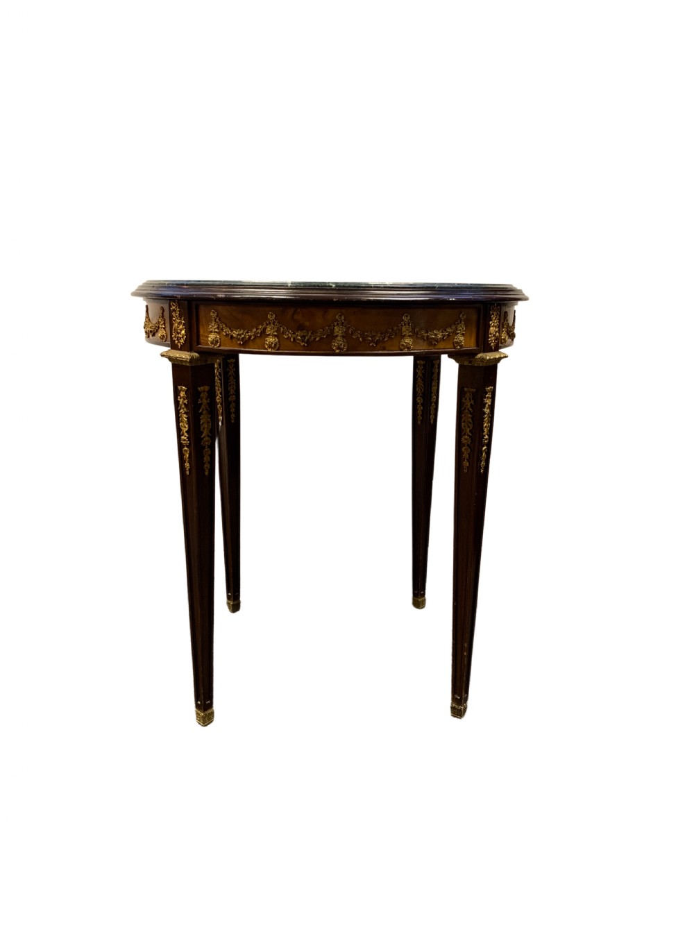A circular centre table featuring a dark green marble top, a dark wooden apron embellished with gilt-bronze festoons, and four tapered legs with gold mounts. View II