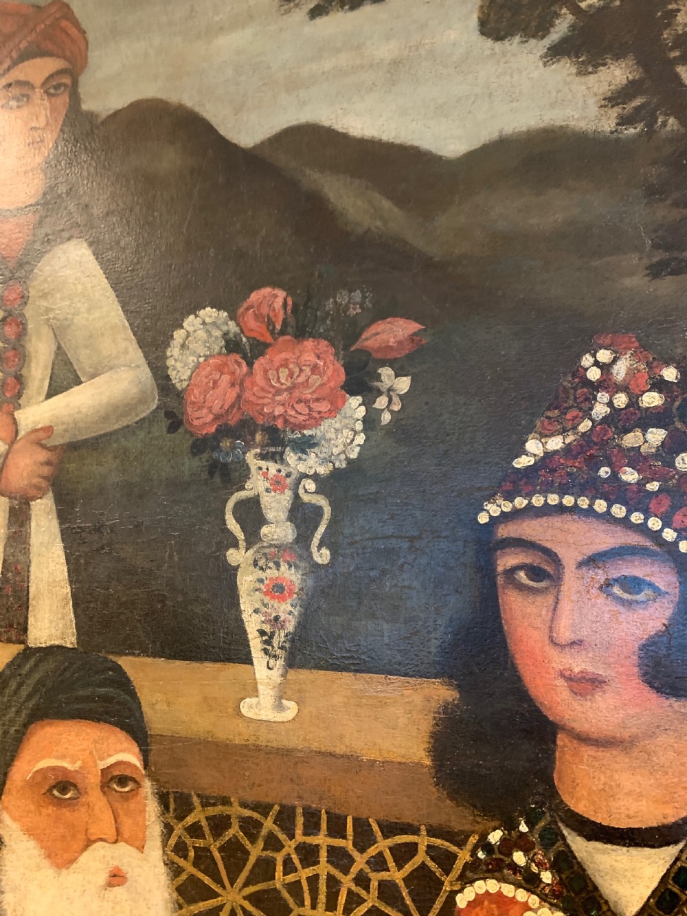 An arched 19th-century Persian Qajar dynasty painting featuring a bearded sage seated alongside a young pupil and an attendant in courtly attire. View IV