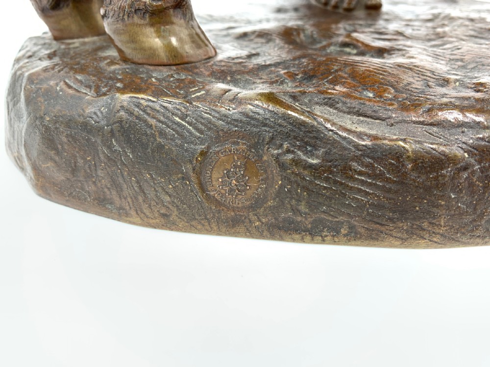 A dark patinated bronze sculpture featuring a man in traditional North African attire leaning against a saddled donkey on a naturalistic base with a title plaque. View IV