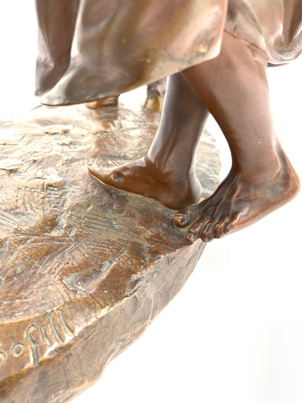A dark patinated bronze sculpture featuring a man in traditional North African attire leaning against a saddled donkey on a naturalistic base with a title plaque. View VIII