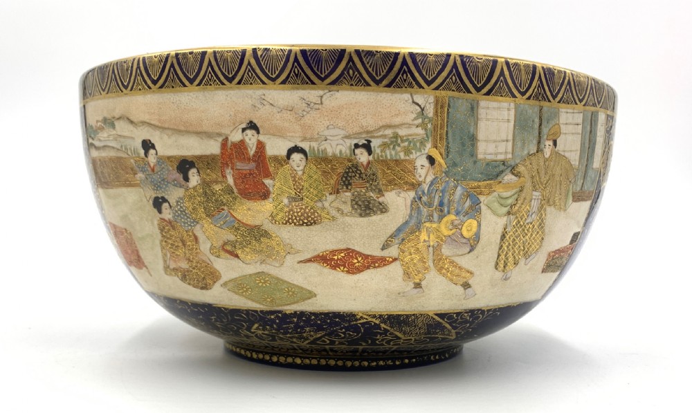 A deep circular Japanese Satsuma earthenware bowl with detailed hand-painted figural scenes, dense gilt borders, and a crackle glaze. View IV