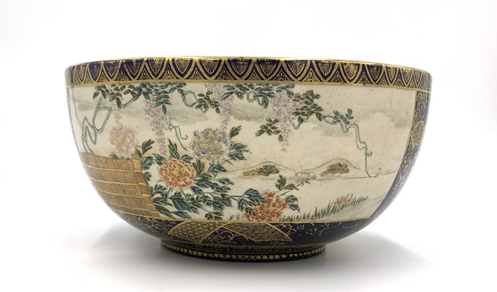 A deep circular Japanese Satsuma earthenware bowl with detailed hand-painted figural scenes, dense gilt borders, and a crackle glaze. View V