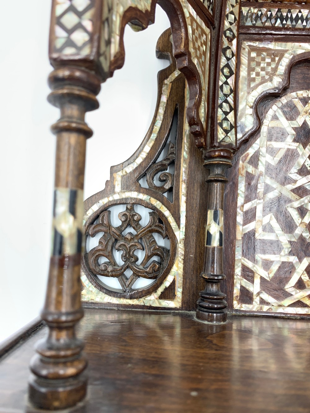 An intricately carved 19th-century Syrian walnut wall bracket featuring architectural arches, a domed canopy, and dense geometric mother-of-pearl inlay. View V