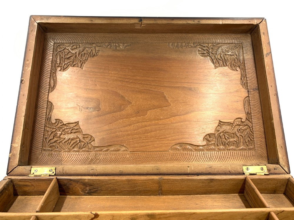 A 19th-century South Indian carved sandalwood jewellery box decorated with high-relief animal and floral motifs, supported by four carved legs. View V