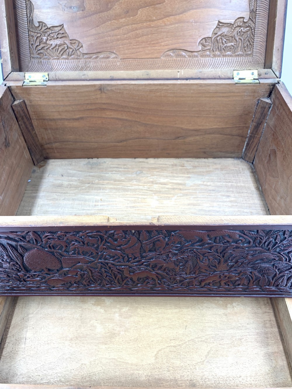A 19th-century South Indian carved sandalwood jewellery box decorated with high-relief animal and floral motifs, supported by four carved legs. View IX