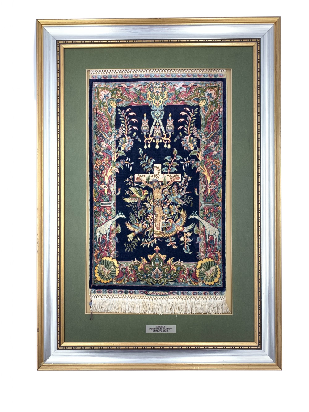 A framed Turkish miniature pure silk Hereke carpet featuring a central crucifix scene surrounded by bird motifs and floral borders.