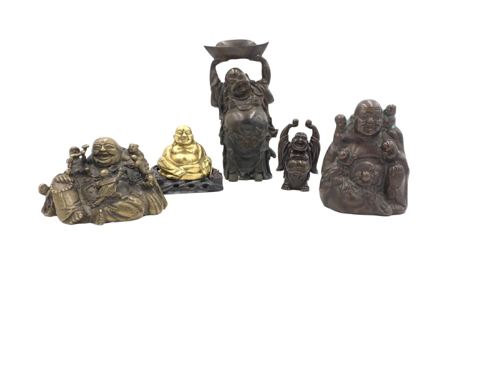 A collection of five cast metal Laughing Buddha statues in various poses and metallic finishes.