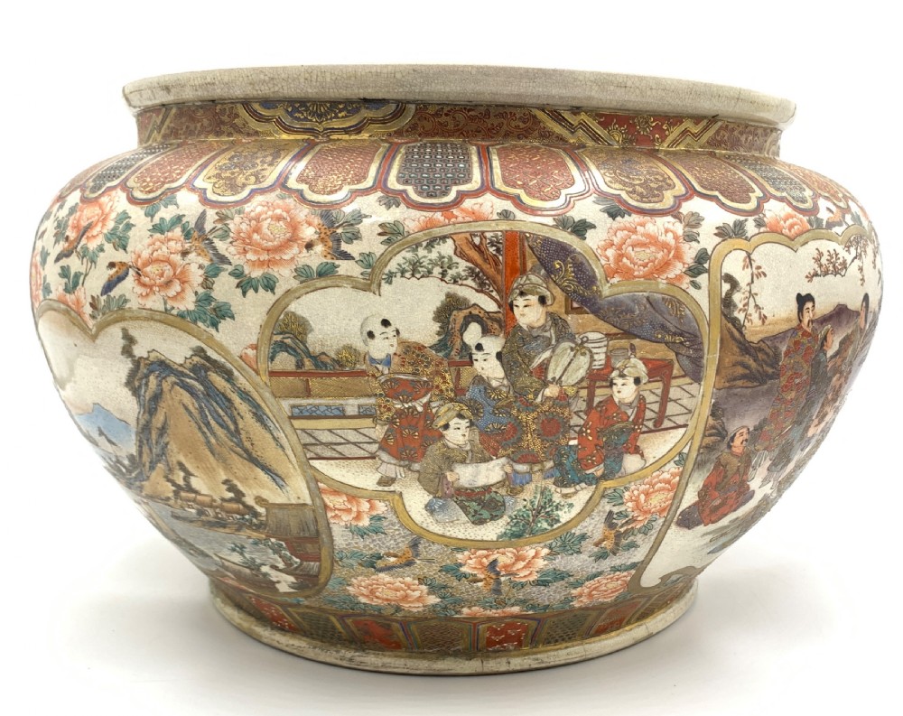 A large bulbous Japanese Satsuma earthenware bowl featuring intricate polychrome enamel scenes of figures in traditional attire, bordered by elaborate gilt geometric patterns on a crackled cream ground. View V