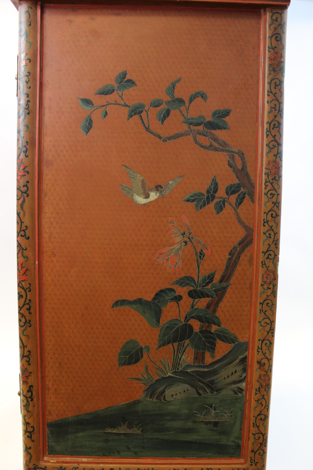 A 19th-century Chinese red lacquer cabinet featuring two doors decorated with carved white relief panels depicting figures, birds, and botanical motifs, fitted with brass lockplates. View IV