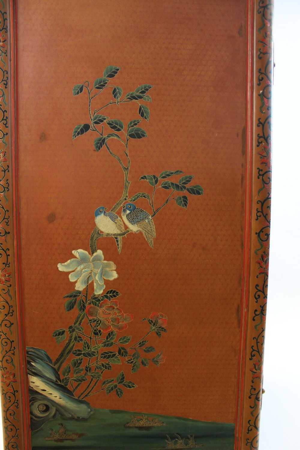 A 19th-century Chinese red lacquer cabinet featuring two doors decorated with carved white relief panels depicting figures, birds, and botanical motifs, fitted with brass lockplates. View VI