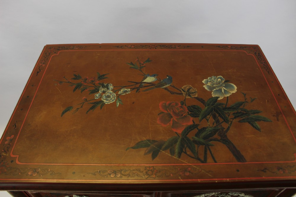 A 19th-century Chinese red lacquer cabinet featuring two doors decorated with carved white relief panels depicting figures, birds, and botanical motifs, fitted with brass lockplates. View XVI