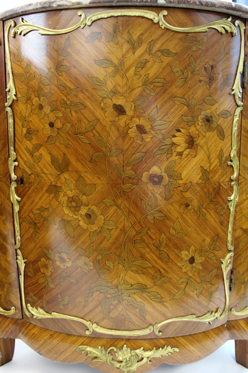 A matching pair of 19th-century French corner cabinets featuring floral marquetry panels, curved doors, gilt bronze mounts, and red-brown marble tops. View III