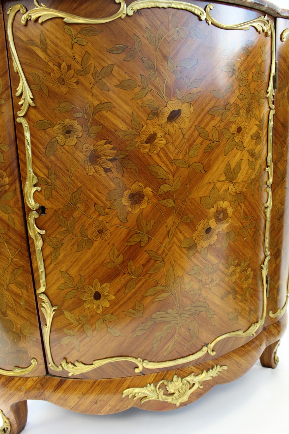 A matching pair of 19th-century French corner cabinets featuring floral marquetry panels, curved doors, gilt bronze mounts, and red-brown marble tops. View IV