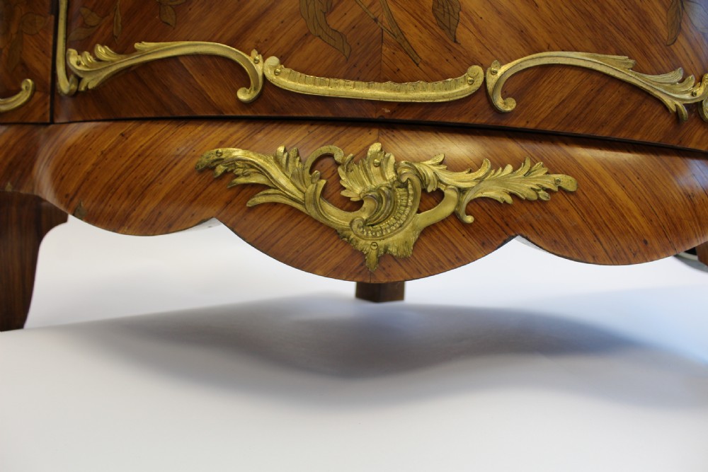 A matching pair of 19th-century French corner cabinets featuring floral marquetry panels, curved doors, gilt bronze mounts, and red-brown marble tops. View V