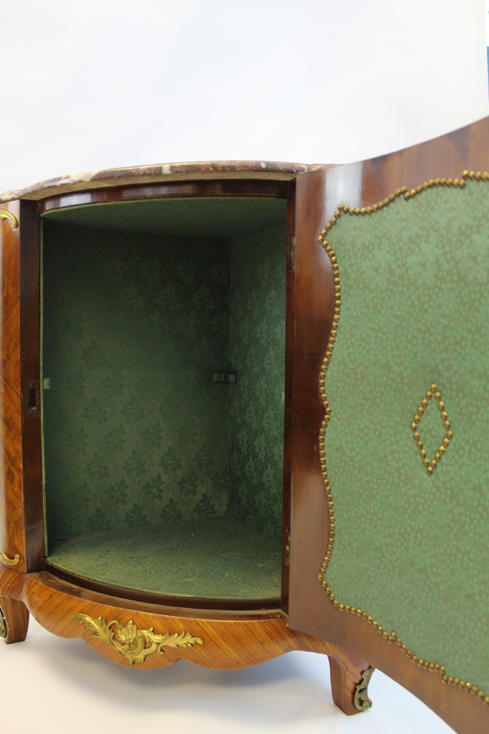 A matching pair of 19th-century French corner cabinets featuring floral marquetry panels, curved doors, gilt bronze mounts, and red-brown marble tops. View VI