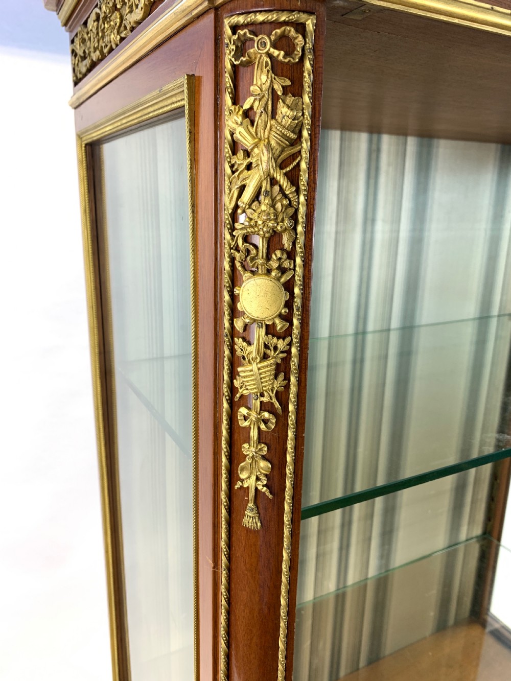 A 19th-century French Louis XVI style mahogany vitrine cabinet featuring glass side panels, gilt bronze mounts, a parquetry lower section, and a marble top. View XIII