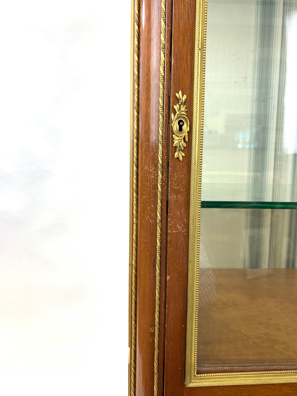 A 19th-century French Louis XVI style mahogany vitrine cabinet featuring glass side panels, gilt bronze mounts, a parquetry lower section, and a marble top. View XV