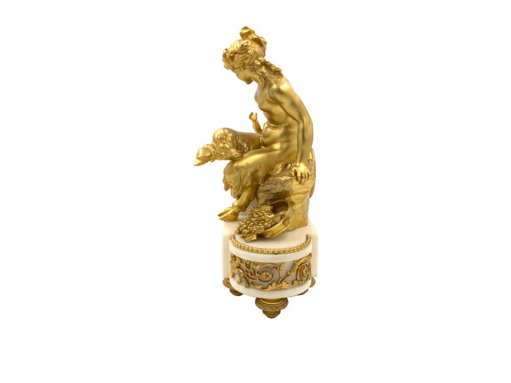 A late nineteenth-century French Louis XVI style gilt-bronze and white marble mantel clock featuring a sculptural bacchante figure alongside an enamel dial. View II