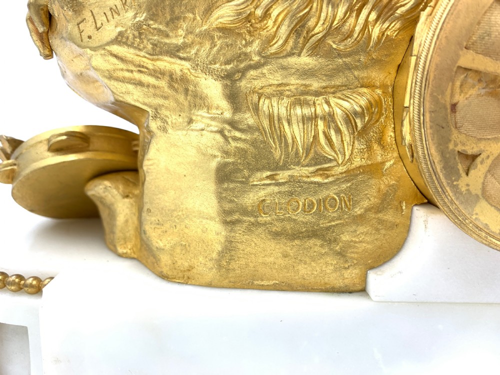 A late nineteenth-century French Louis XVI style gilt-bronze and white marble mantel clock featuring a sculptural bacchante figure alongside an enamel dial. View VIII