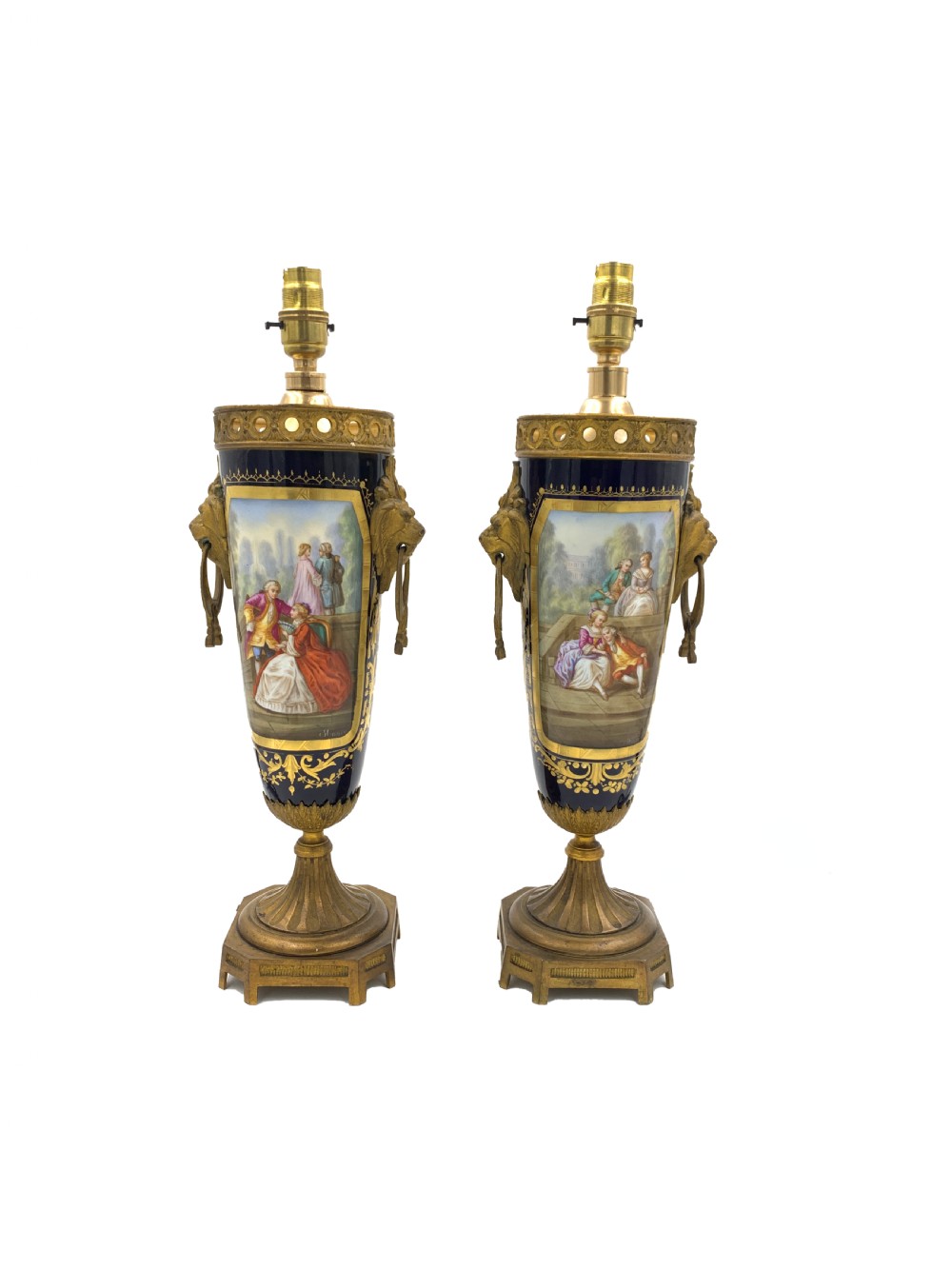 A pair of French Sevres style cobalt blue porcelain table lamps featuring hand-painted romantic scenes, gilt bronze handles, and pleated cream fabric shades. View II