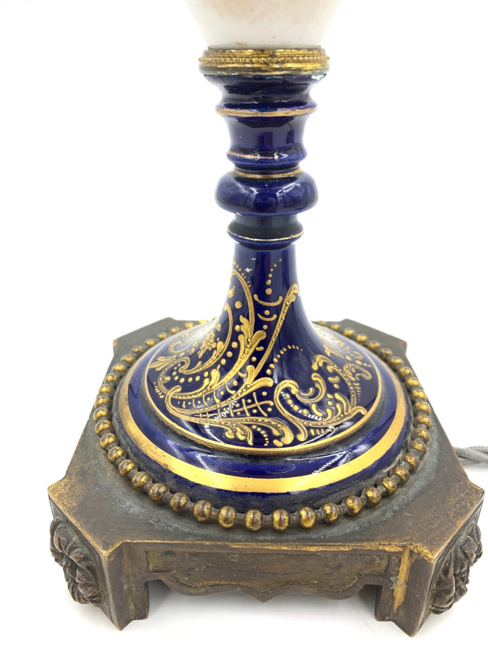 A 19th-century French Sevres style porcelain urn table lamp featuring hand-painted figures, cobalt blue accents, gilt detail, and a pleated silk shade. View VIII