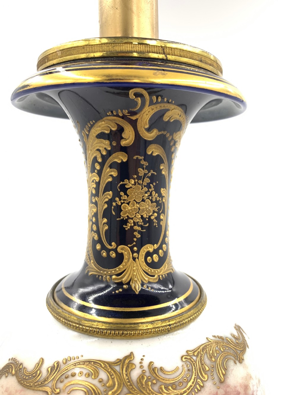 A 19th-century French Sevres style porcelain urn table lamp featuring hand-painted figures, cobalt blue accents, gilt detail, and a pleated silk shade. View IX