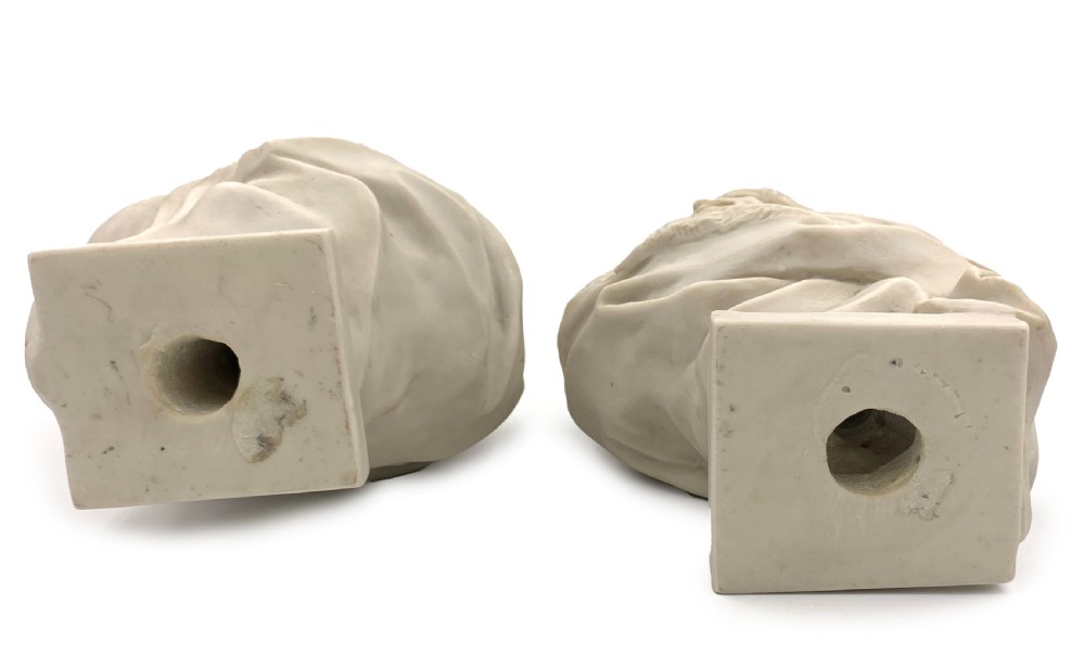 A pair of carved off-white marble busts depicting a man and woman in detailed Orientalist dress and headwear on integral square bases. View IV