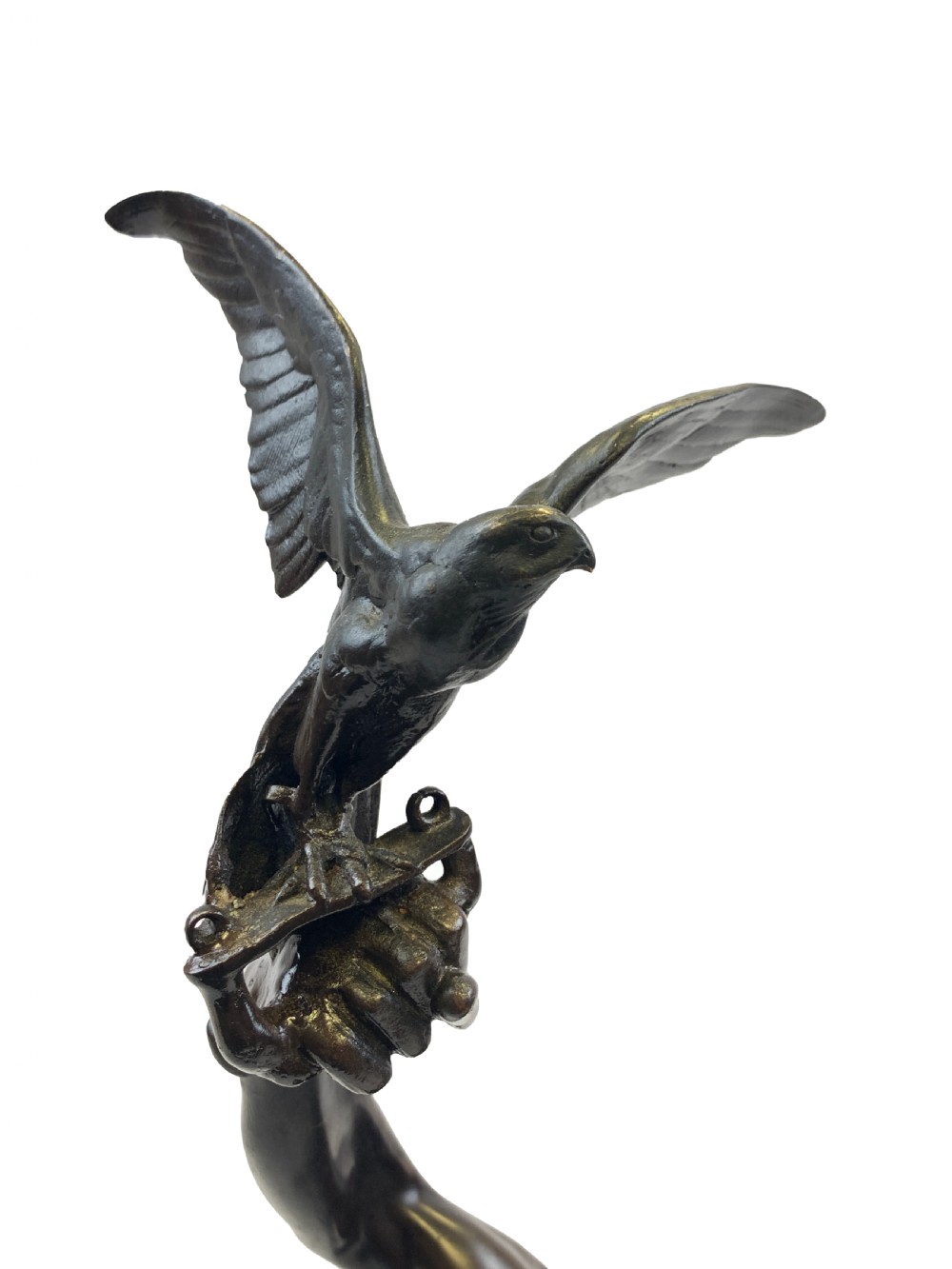 A dark brown patinated bronze sculpture depicting an Arab falconer holding a falcon overhead while standing on a circular base. View VIII